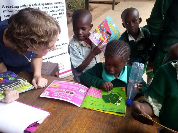 Author Jenny Valentine investigates a book with a STD 1. student at Kawangware Primary School during the #JazaMatatu na Vitabu Mini Launch.